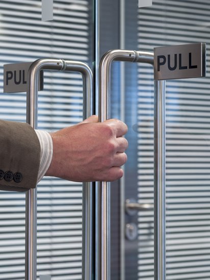 Algunas puertas necesitan señales como esta que dice "jale", para que las personas sepan qué hacer. Puerta con una señal que dice "jale".