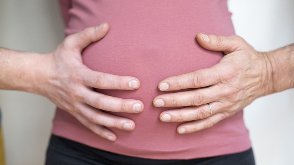 Mulher grávida segurando a barriga