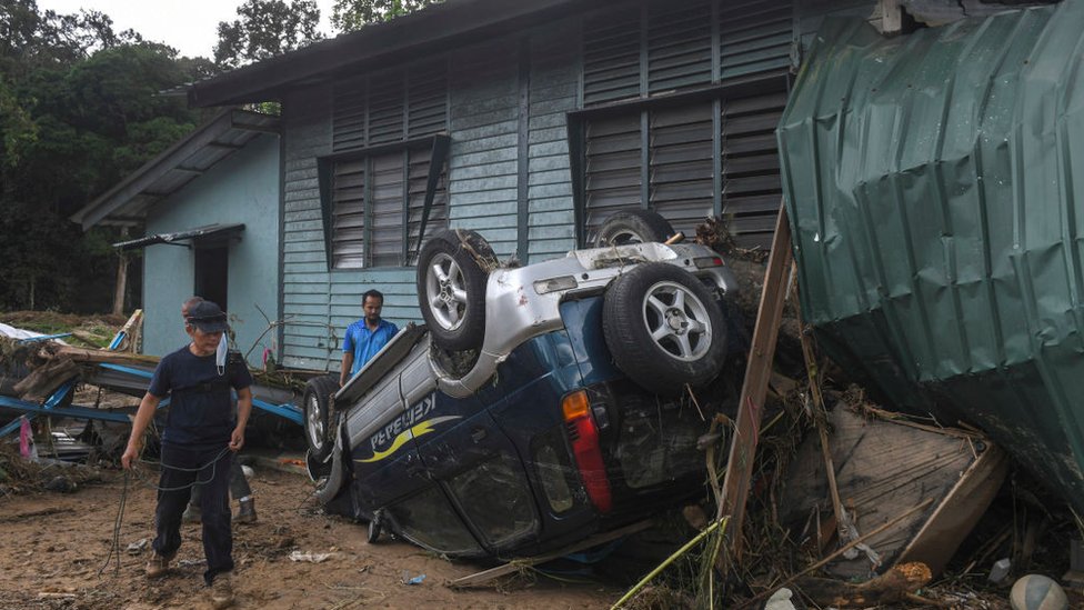 Warga membersihkan rumahnya yang terkena banjir di Hulu Langat, luar Kuala Lumpur, Malaysia pada 20 Desember 2021