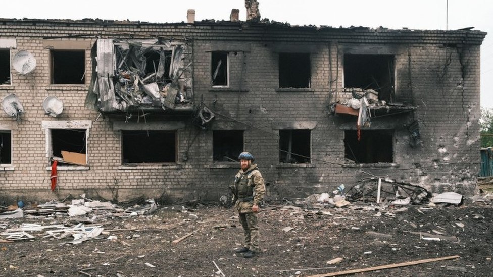 Ukrajinski policajac proverava oštećenu zgradu u Vovčansku