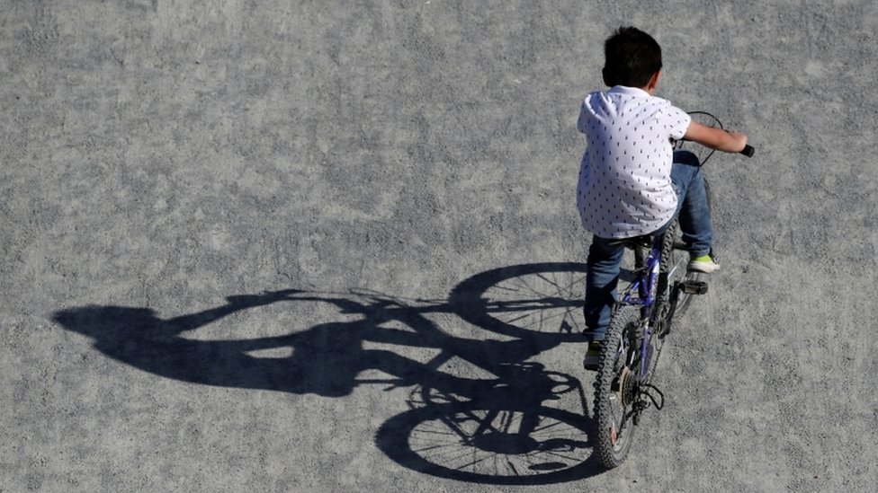 Мальчик катается на велосипеде в парке в Брюсселе, поскольку Бельгия остается взаперти