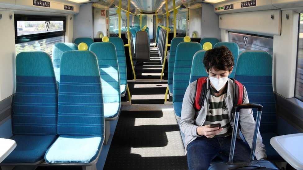 A man on a train with a mask on