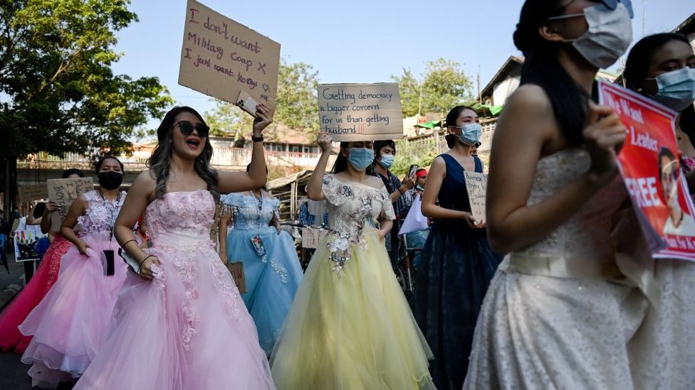 Myanmar women in wedding gowns holds up placards during a demonstration
