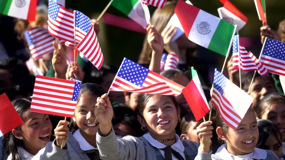 Niñas ondean banderas de México y EE.UU.