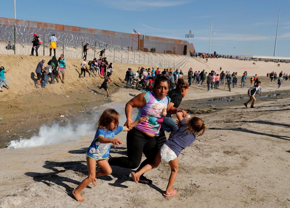 Honduraslı göçmen Maria Meza (ortada), beş yaşındaki ikiz kızlarıyla birlikte Meksika - ABD sınırında atılan göz yaşartıcı gazdan kaçarken.