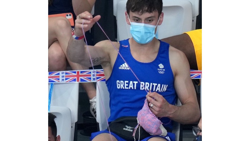 Tom Daley knitting in the stands at the Tokyo Aquatic Centre