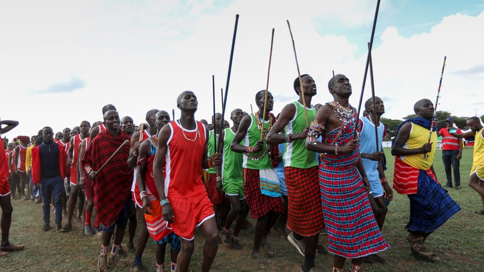 مقاتلو الماساي في زيهم التقليدي يغنون أثناء أدائهم حركات الإحماء قبل بدء الألعاب.