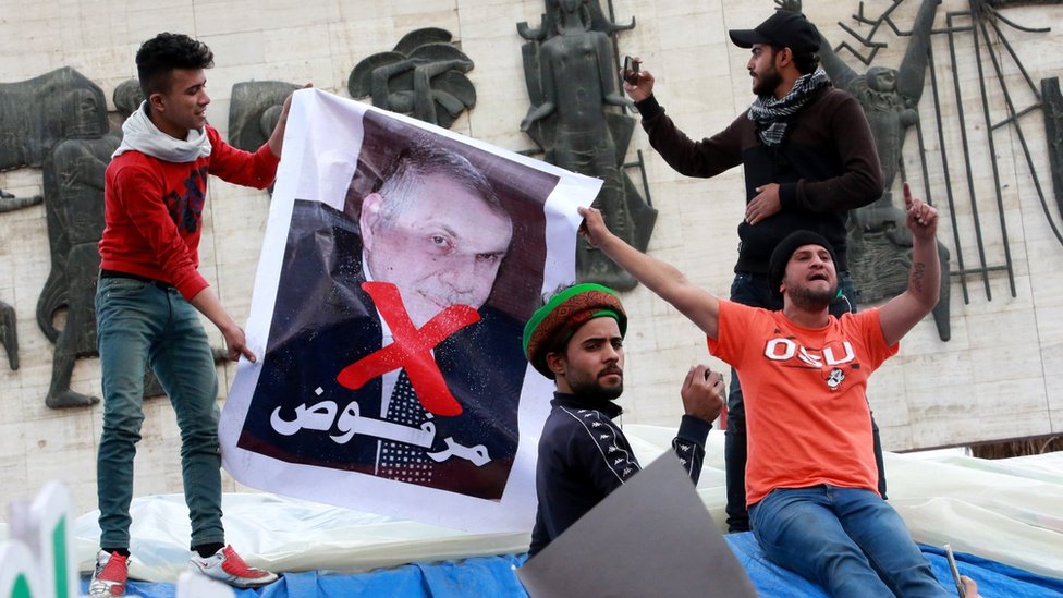 Иракцы держат плакат с изображением бывшего назначенного премьер-министром Мохаммеда Аллави и слова «отклонено» на площади Тахрир в Багдаде (1 марта 2020 г.)