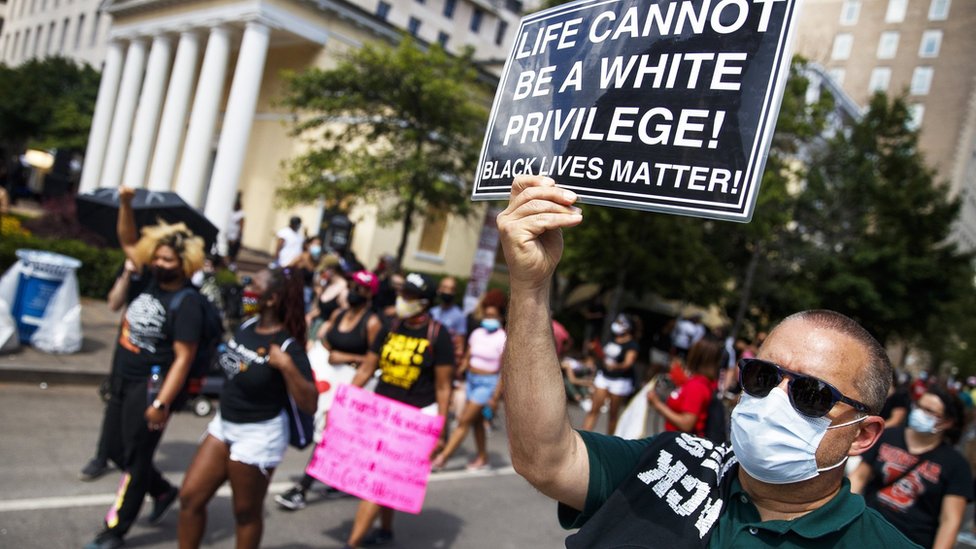Manifestante con un cartel que dice "la vida no puede ser un privilegio blanco", en Washington D.C.