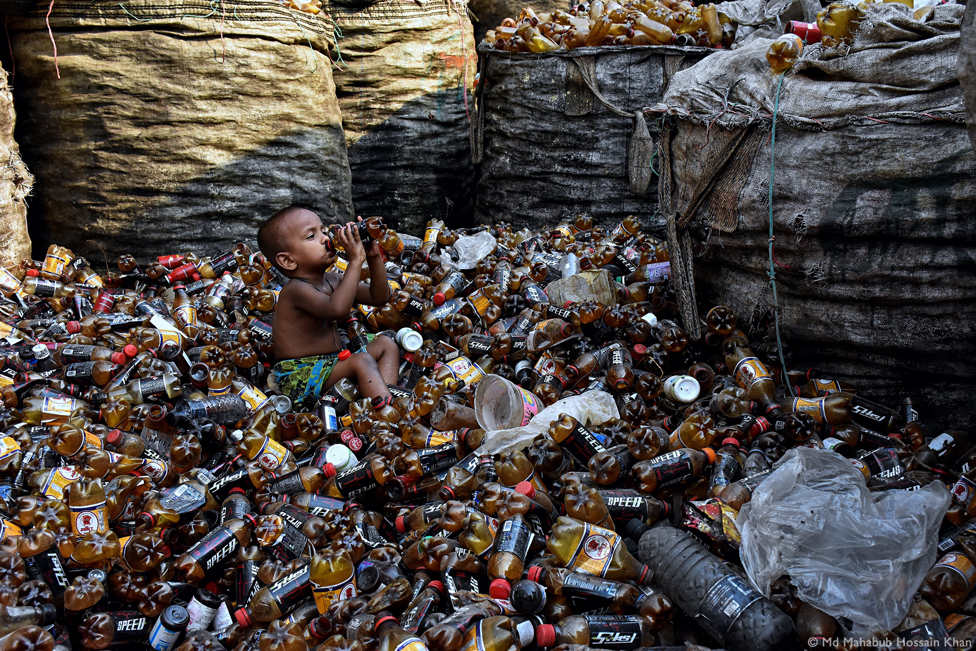 Un niño rodeado de botellas