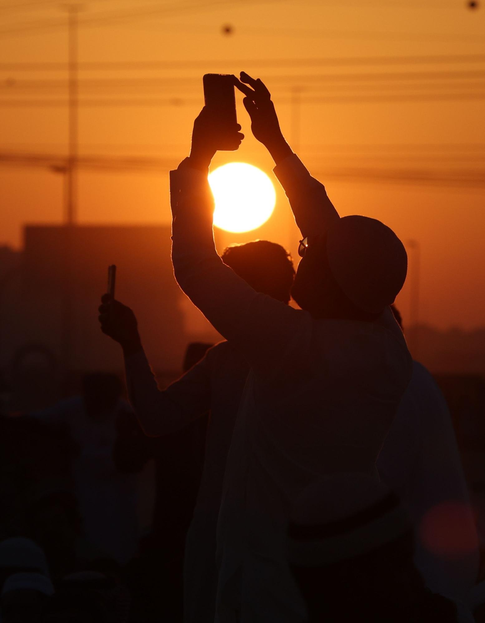 مسلمون يلتقطون الصور خلال صلاة عيد الفطر