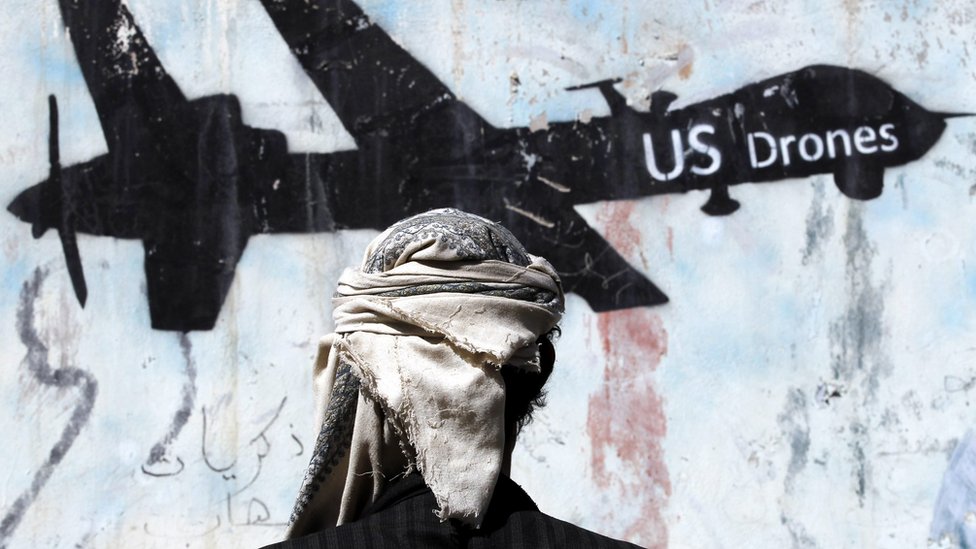 A Yemeni stands in front of a graffiti protesting against US drone strikes in Sanaa, Yemen (29 January 2017)