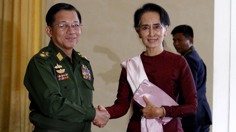 Genelkurmay Başkanı chief Min Aung Hlaing, Aung San Suu Kyi ile el sıkışırken.