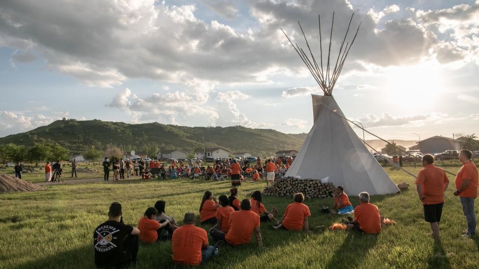 First Nations community members gather during a vigil in the recently discovered unmarked graveyard in a former catholic Indian residential school in Cowessess first nation community of Marieval, in Saskatchewan, Canada