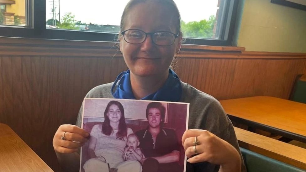 Holly Crouse holds a photo of her murdered parents
