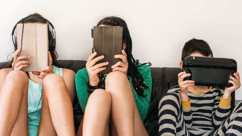 Adolescentes y niños enfocados en sus dispositivos digitales