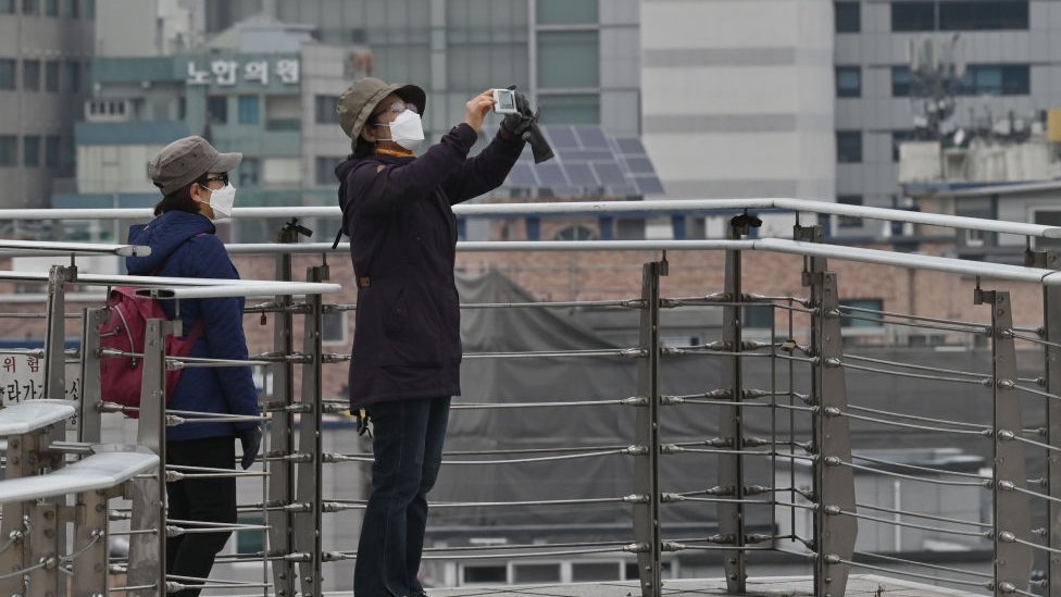 Ciudadana tomando fotos con su celular en la ciudad surcoreana de Daegu.