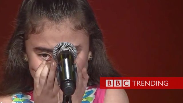 a girl crying in front of a microphone