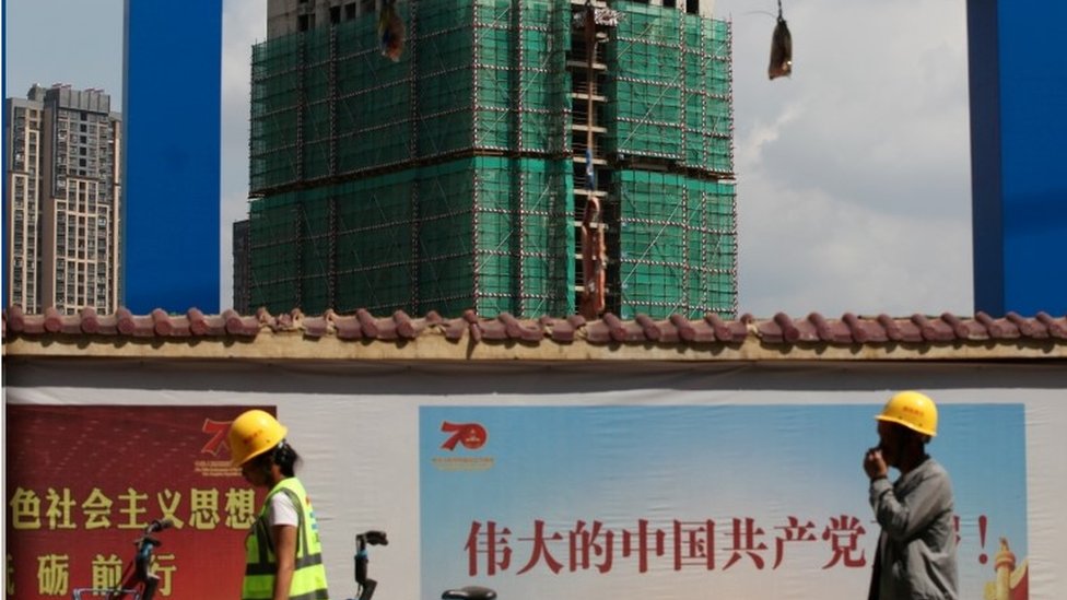Workers walk past a construction site of residential buildings by property developer Country Garden in Kunming, Yunnan province, China September 17, 2019