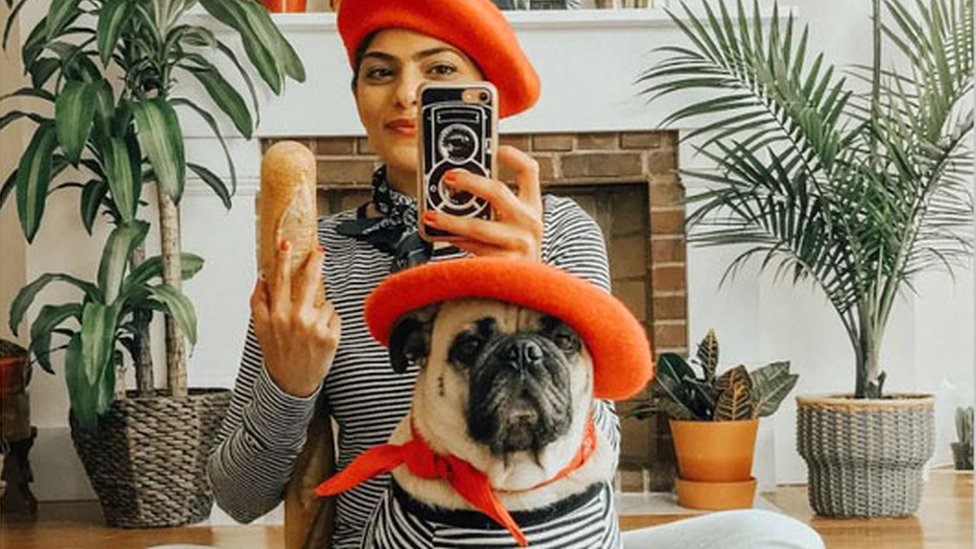 Woman in yoga clothes with pug dog is at home at daytime 15460267