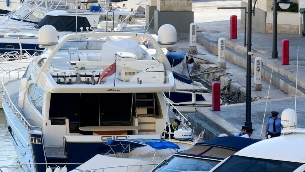Полицейские покидают роскошную яхту Gio, принадлежащую бизнесмену Йоргену Фенеку, после того, как ее сопровождают обратно в порт Портомазо в Сент-Джулиансе, Мальта