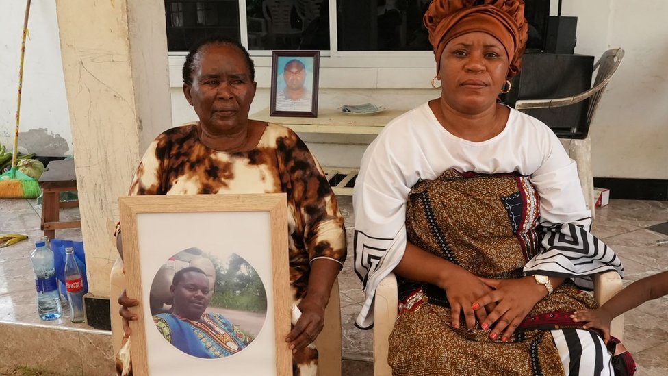 Dos mujeres de la familia de Nemes Tarimo, Roida Sambulika y Rehema Kigobe. Sambulika sostiene una fotografía del hombre muerto.