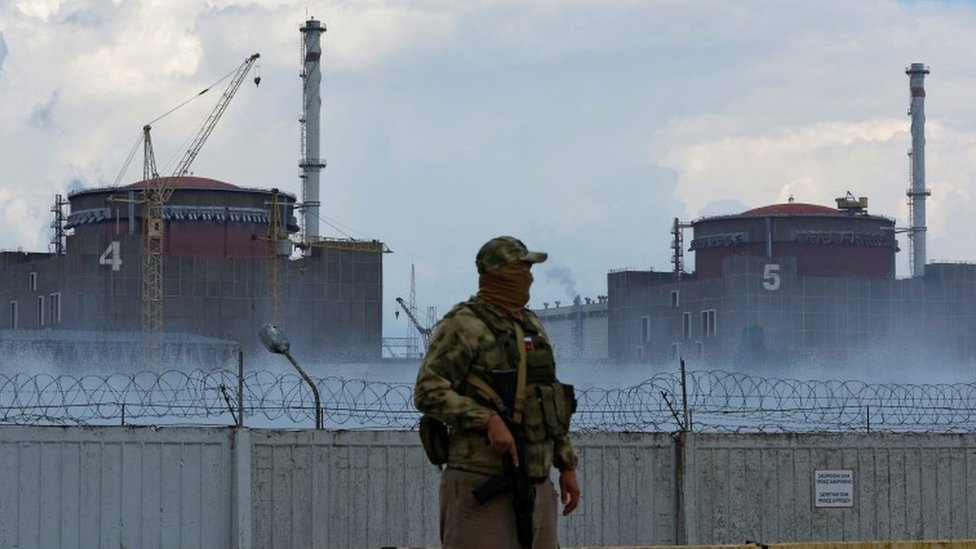A soldier with reactors number four and five in the background