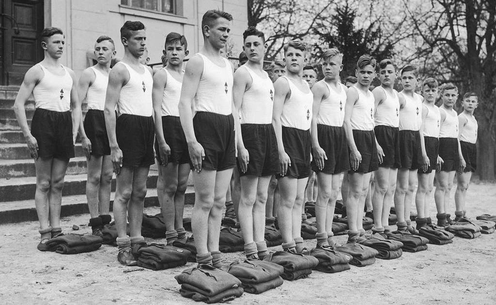Un grupo de jóvenes desfilando con ropa deportiva en una Napola, alrededor de 1935.