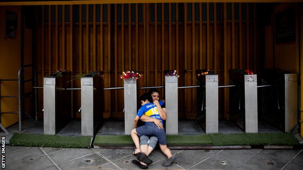 A mother and son mourn Maradona outside La Bombonera