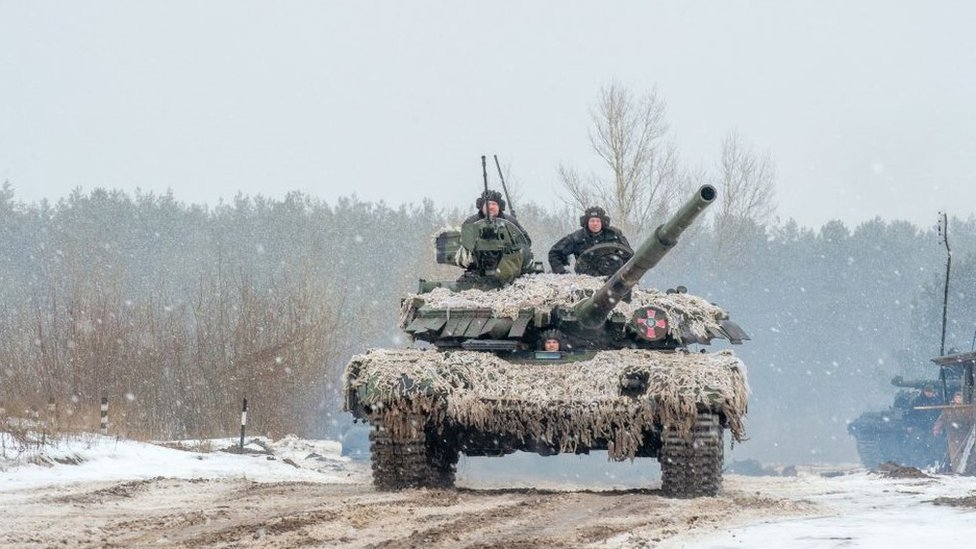 Ukrainian troops on board a tank, conducting live-fire exercises