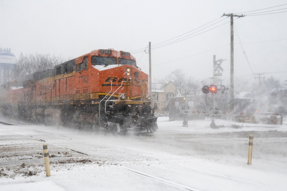 A freight train passes as heavy snowfall begins in a western suburb of Chicago as a winter storm arrives in the Midwest.