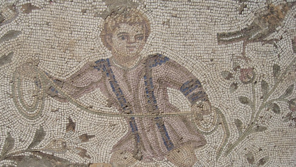 Mosaico romano retrata menino pegando aves com corda