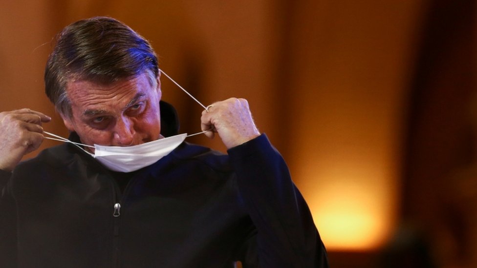 Bolsonaro tirando máscara em ambiente interno