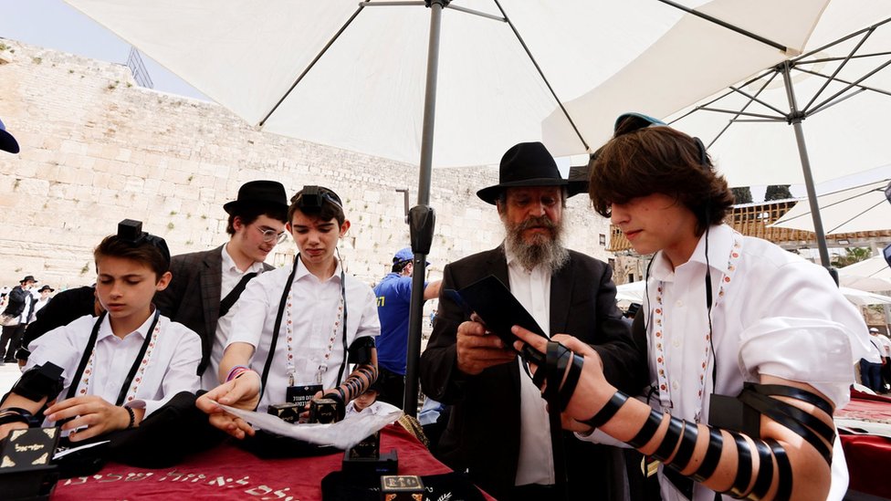 Judíos de varias edades se juntan para rezar.