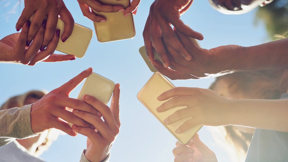 Grupo de personas con celulares.