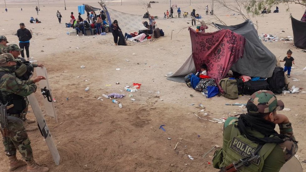 Los migrantes acampan a la intemperie en una zona con duras condiciones climáticas y sin acceso a agua o baños.