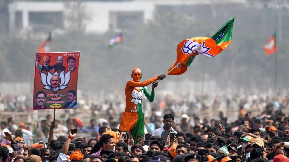 Pendukung Bharatiya Janata (BJP) mengibarkan bendera