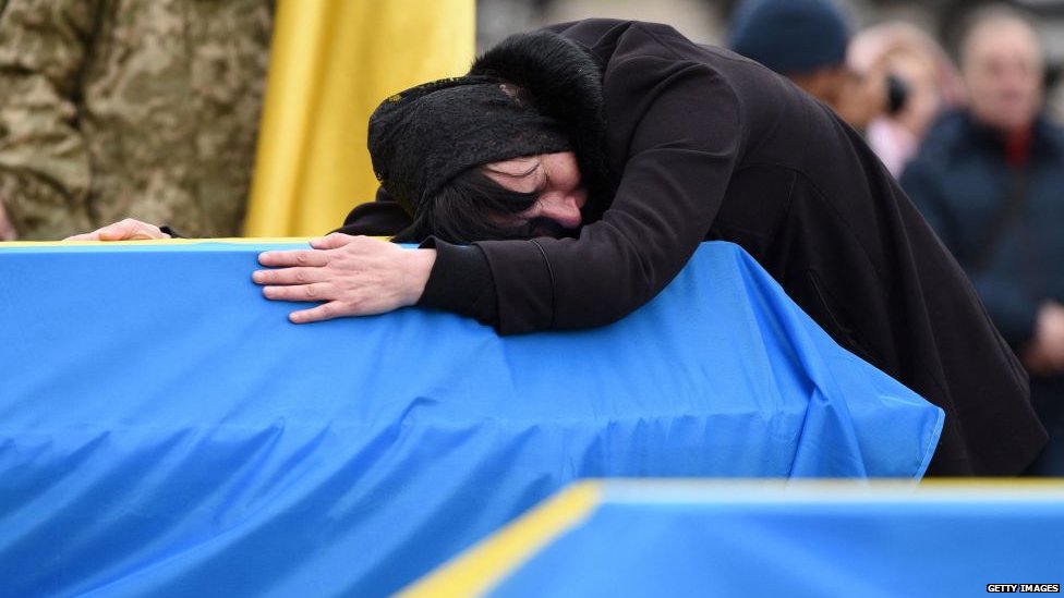 Woman cries on coffin in Ukraine