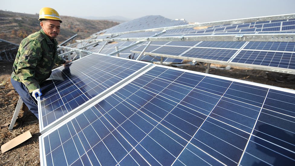China está apostando por las energías renovables, como la solar. Un trabajador instala un panel solar en China.