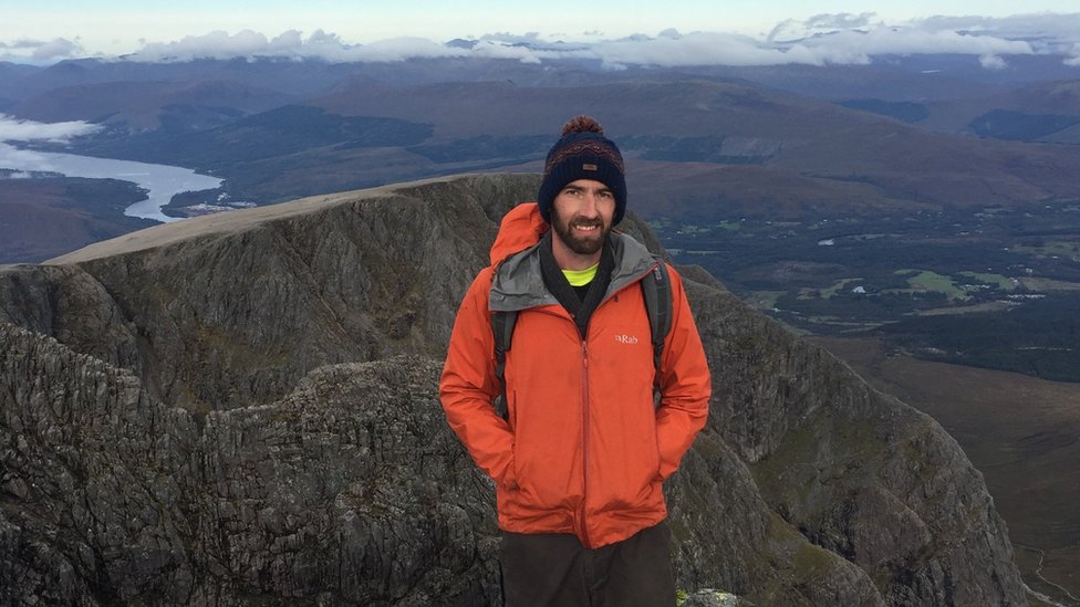 Barny Erdman dressed in hiking gear and pictured against a landscape