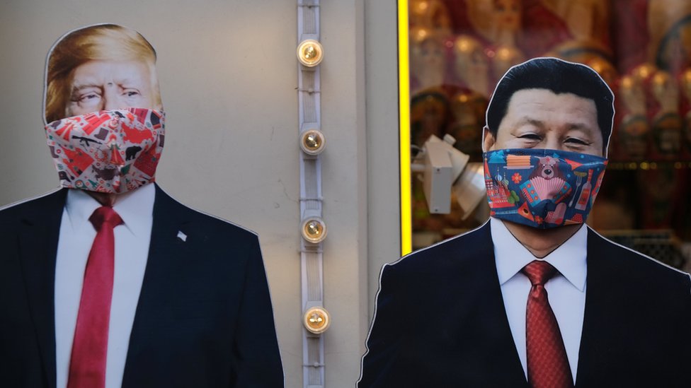 Картонные вырезки президента США Дональда Трампа и президента Китая Си Цзиньпина с защитными масками, широко используемыми в качестве профилактической меры против коронавирусной болезни (COVID-19), возле сувенирного магазина в Москве, Россия