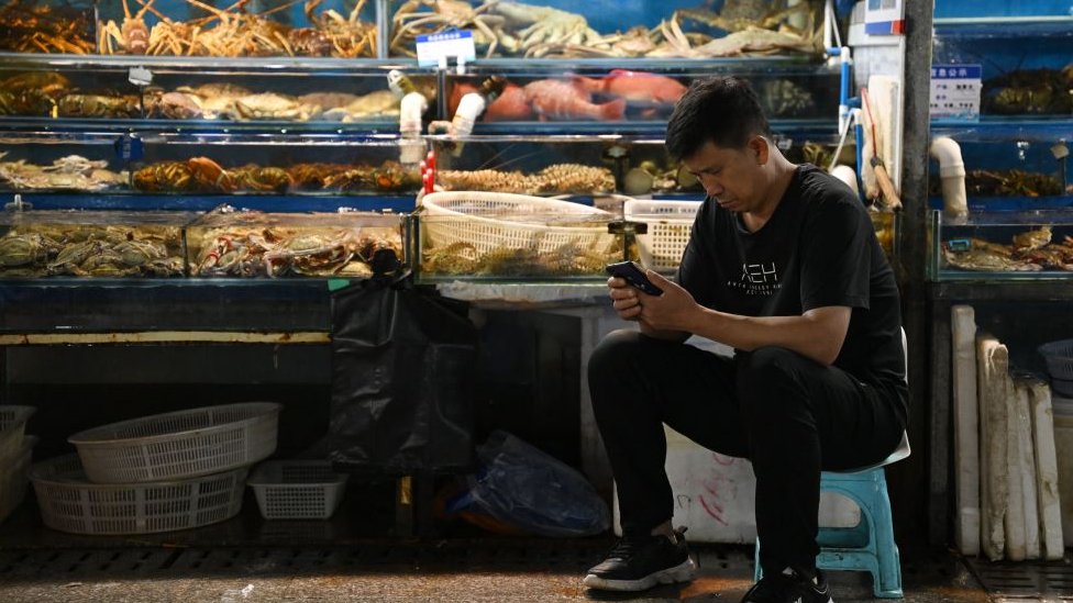 北京某水產市場內一名攤主在等待顧客光顧（24/8/2023）