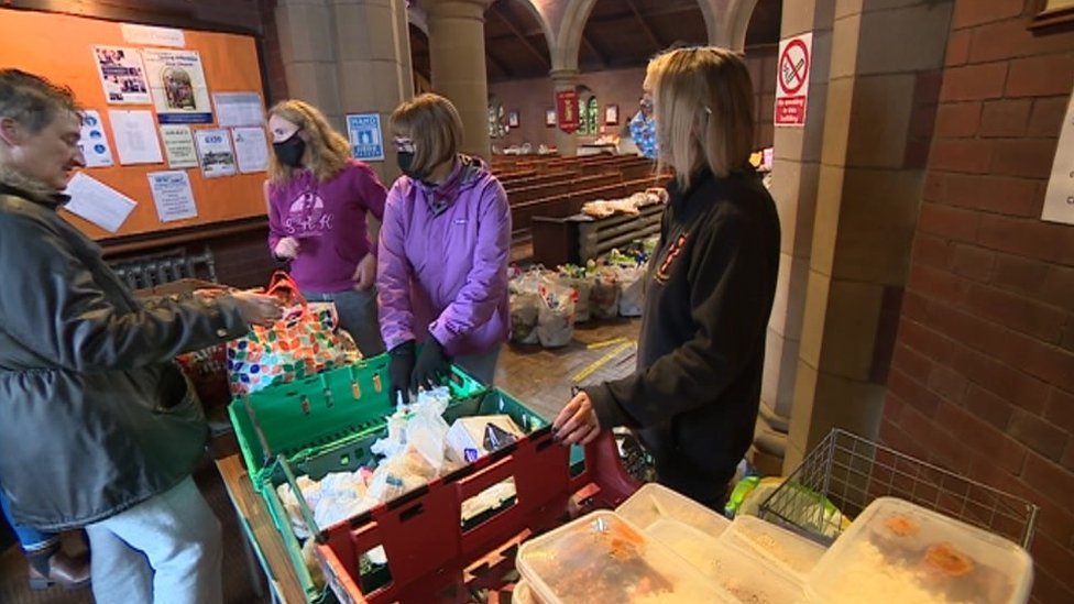 Волонтеры раздают продукты в продовольственном банке St Aidan's Kitchen