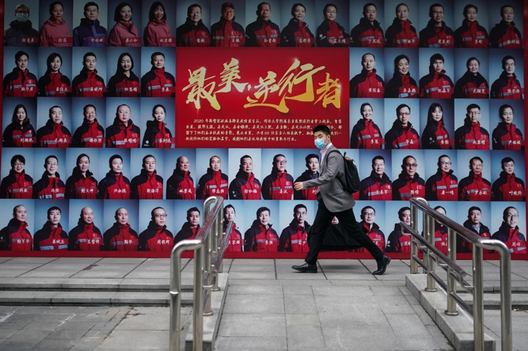 上海一名男子走過致敬武漢醫護人員的宣傳海報。