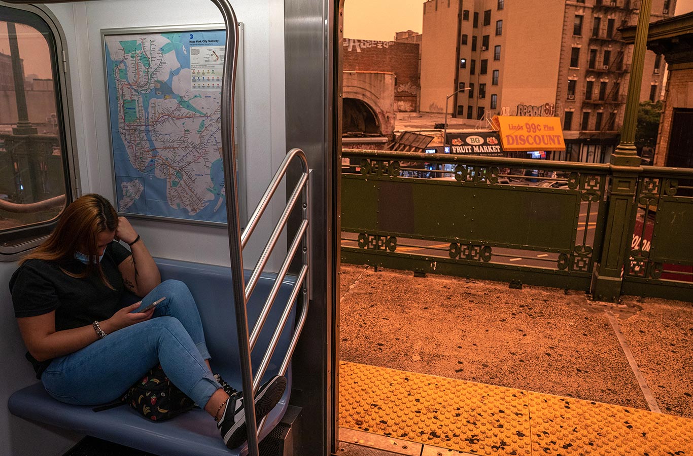 A person on the subway wears a face mask as smoky haze from wildfires in Canada blankets a neighborhood