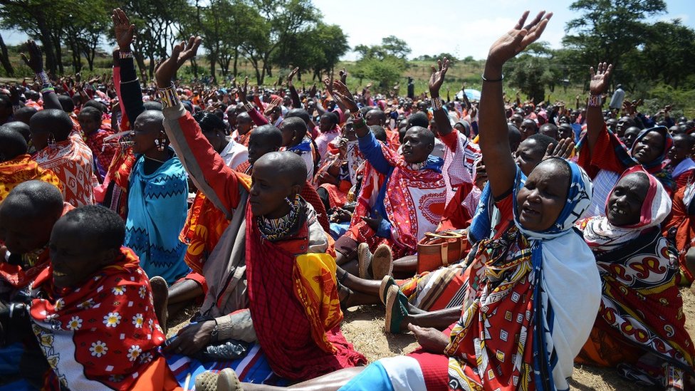 Kenyan Maasai women raise their hands as they gather during a meeting dedicated to the practice of female genital mutilation on June 12, 2014, in Enkorika, Kajiado, 75km from Nairobi.