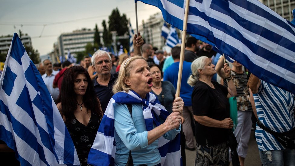 Žena nosi grčku zastavu tokom demonstracija u Atini, 16. jun 2018