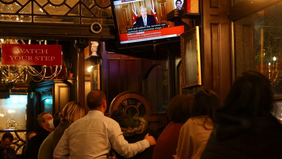 People inside a pub in Westminster watching Boris Johnson announce new lockdown measures