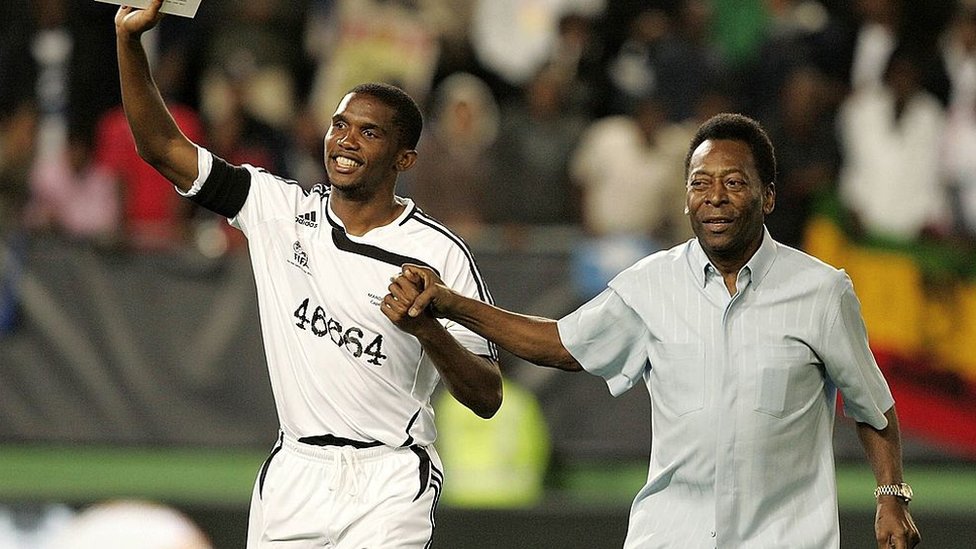 بيليه ونجم كرة القدم الكاميروني السابق صامويل إيتو يحييان المشجعين في مباراة تكريم لنيلسون مانديلا في عام 2007