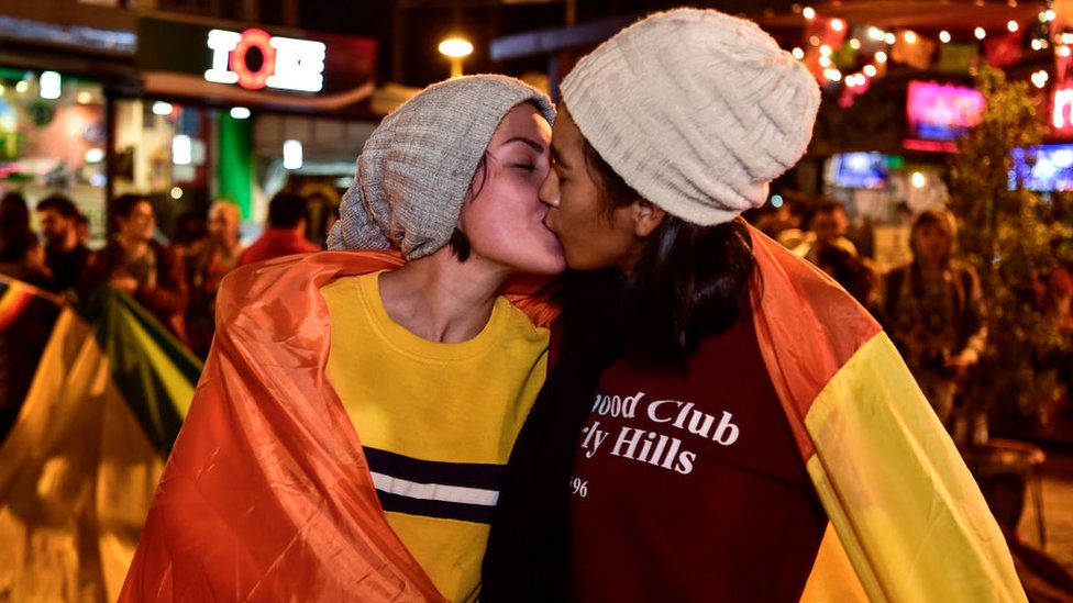 Una pareja celebra con un beso la decisión de la Corte de Ecuador.